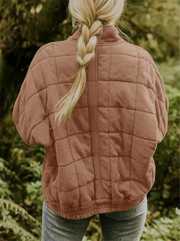 Roze gequilte oversized jas gedragen door vrouw met gevlochten haar buiten | Boutique Moda