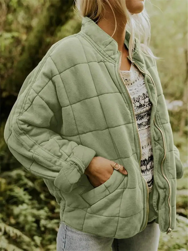 Groen gewatteerd jasje met opstaande kraag, gedragen door een vrouw buiten | Boutique Moda