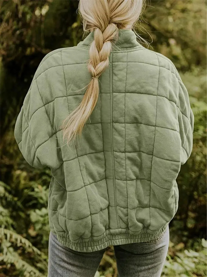 Groene gewatteerde jas met geblokt patroon, gedragen door vrouw buiten | Boutique Moda