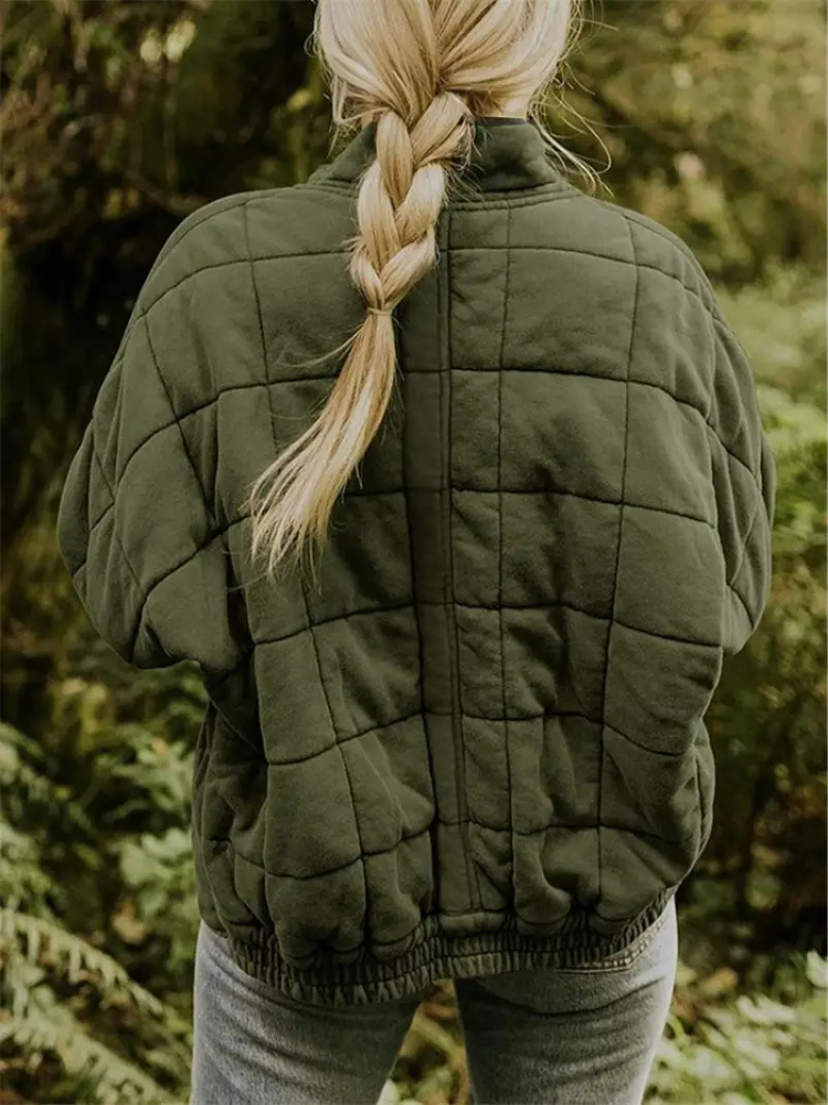 Groene gewatteerde jas met vierkant patroon, gedragen door vrouw buiten | Boutique Moda