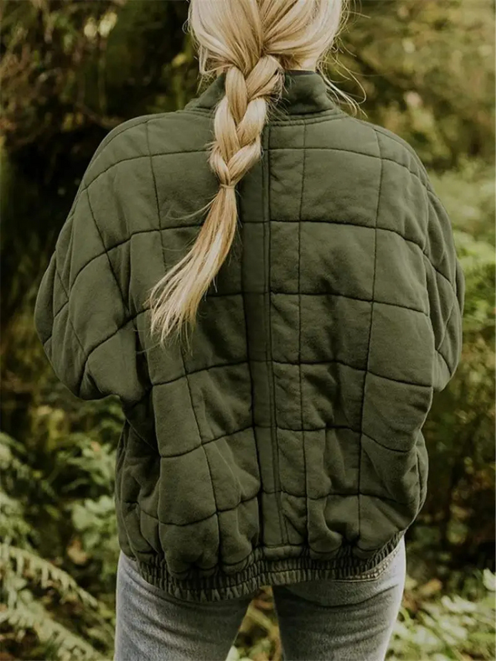 Groene gewatteerde jas met vierkant patroon, gedragen door vrouw buiten | Boutique Moda