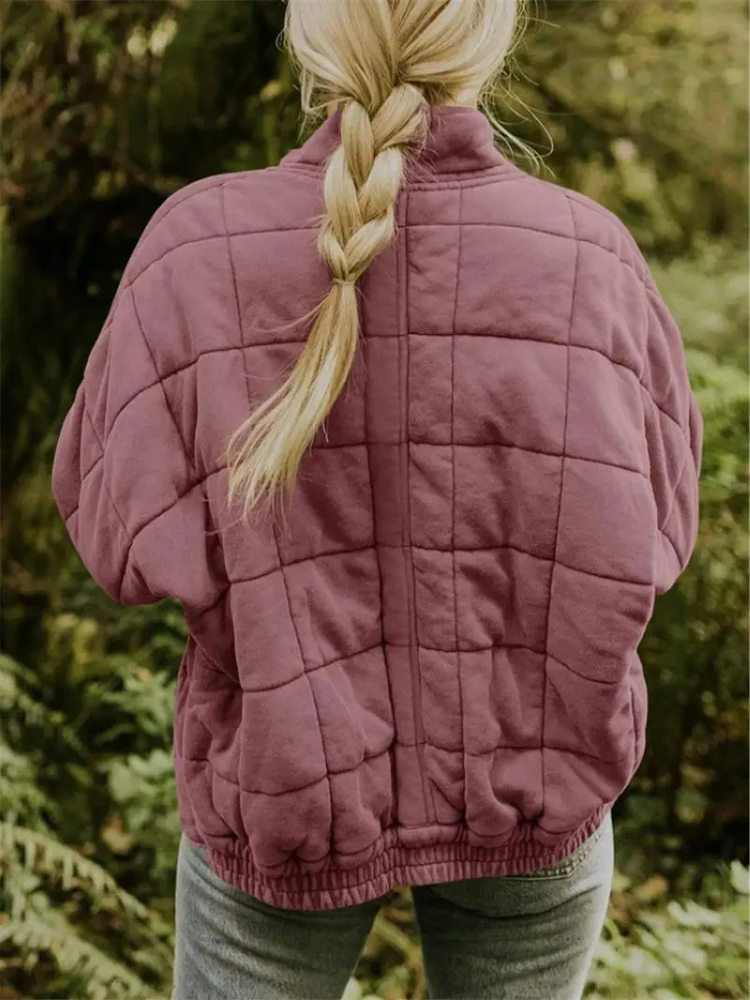 Bordeauxrode gewatteerde jas met vierkant patroon, gedragen door vrouw buiten | Boutique Moda