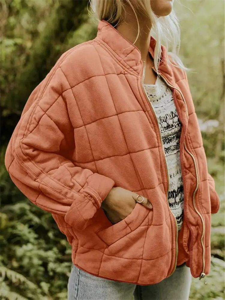 Roze gequilte oversized jas gedragen door vrouw met spijkerbroek buiten | Boutique Moda