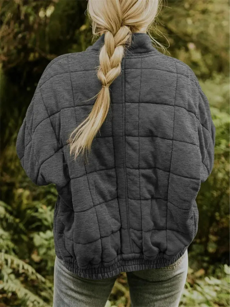 Grijze gewatteerde oversized jas met ritssluiting, gedragen door vrouw buiten | Boutique Moda