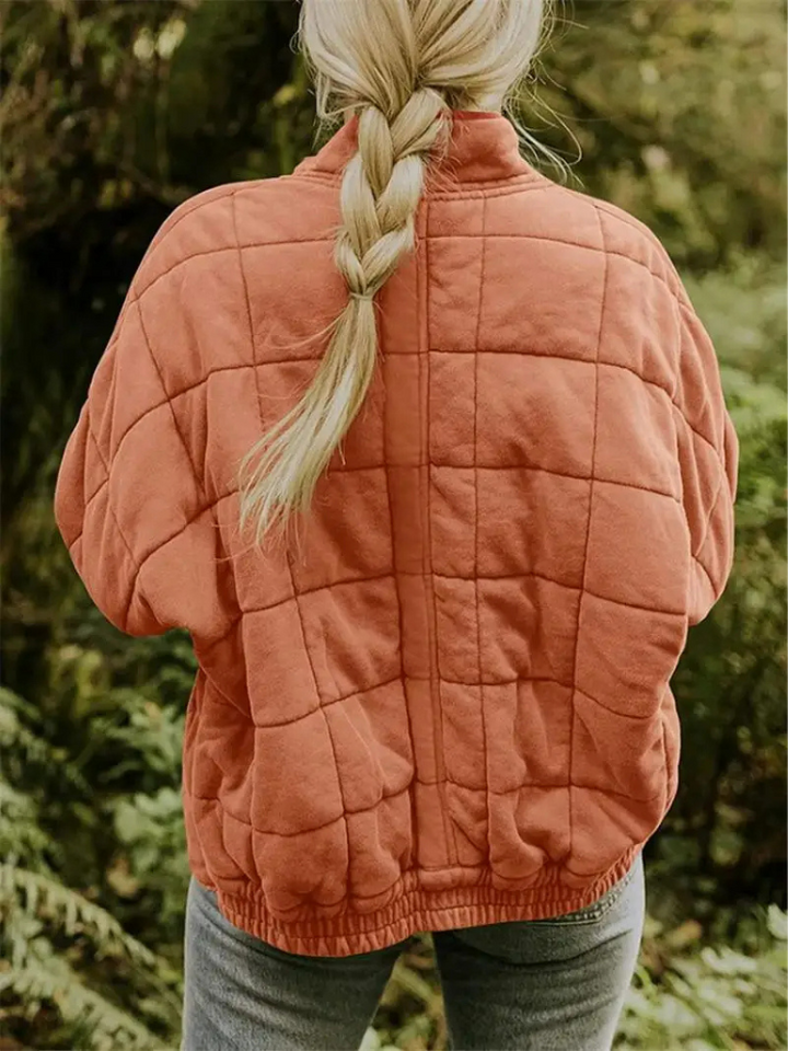 Roestoranje gewatteerde jas met geruit patroon, gedragen door vrouw buiten | Boutique Moda