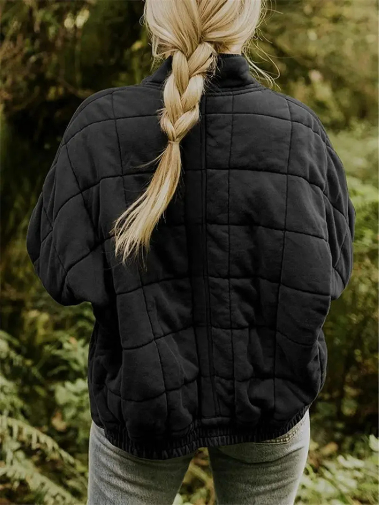 Zwarte gewatteerde oversized jas met geruit patroon, gedragen door vrouw | Boutique Moda