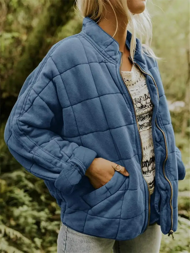 Blauwe gequilte oversized jas gedragen door vrouw met handen in zakken | Boutique Moda