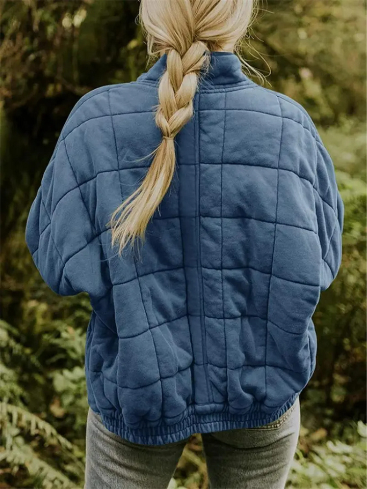 Blauwe gequilte oversized jas gedragen door vrouw met vlecht buiten | Boutique Moda