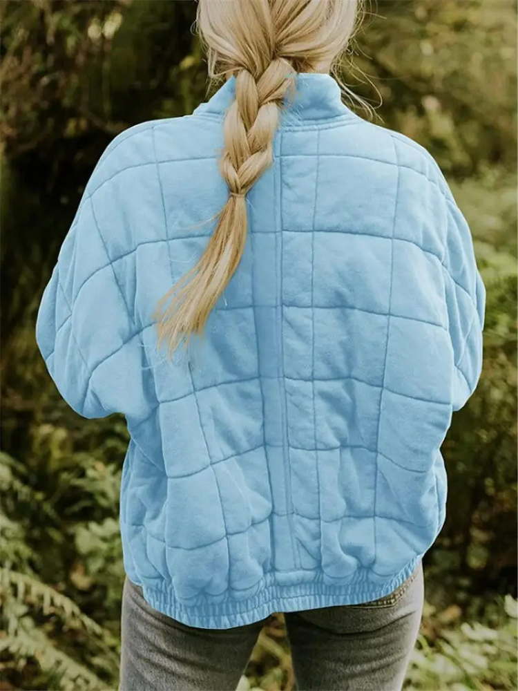 Lichtblauwe gequilte oversized jas gedragen door vrouw met blonde vlecht | Boutique Moda