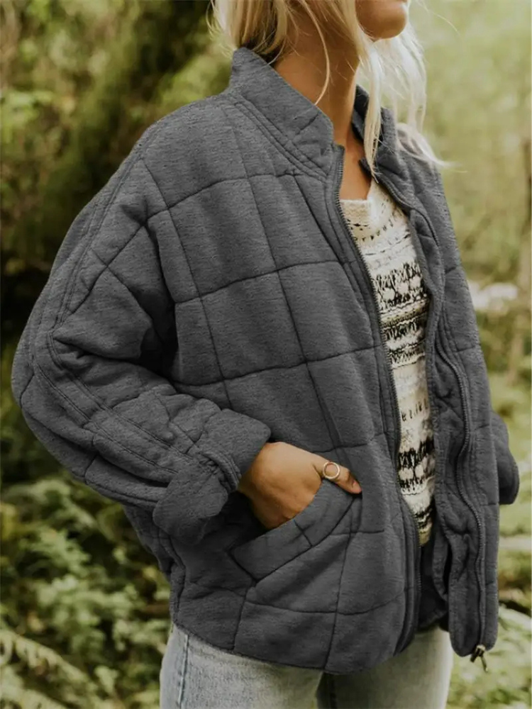 Grijze gequilte oversized jas gedragen door vrouw met hand in zak | Boutique Moda