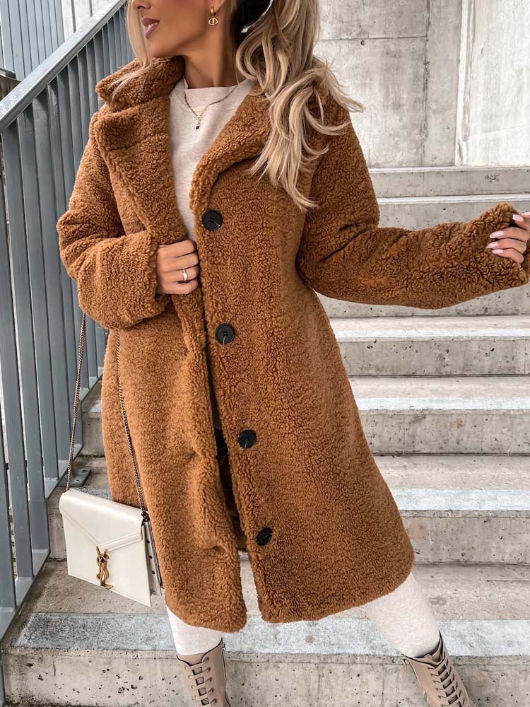Kameelkleurige lange teddy jas gedragen door vrouw op buitentrap | Boutique Moda