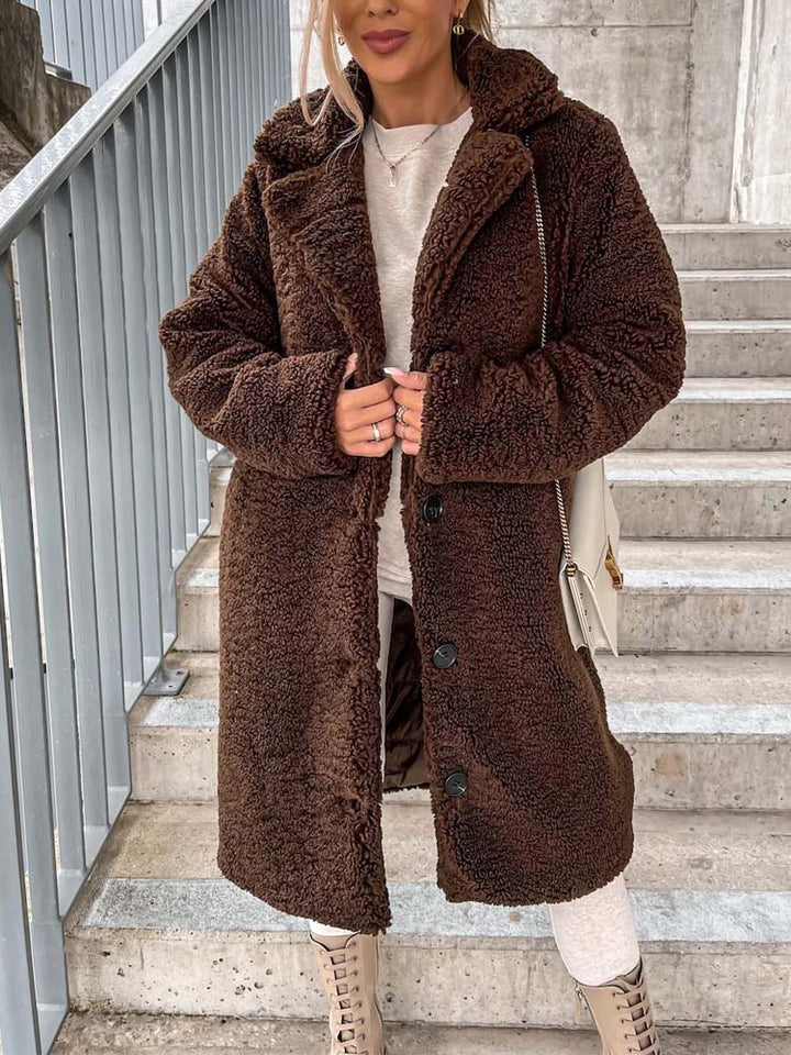 Bruine lange teddy jas met knopen, gedragen door vrouw op trap | Boutique Moda