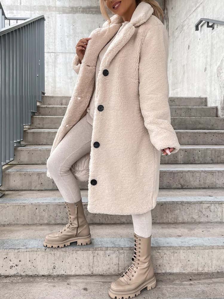Vrouw draagt lange beige teddy jas met knopen op trap | Boutique Moda