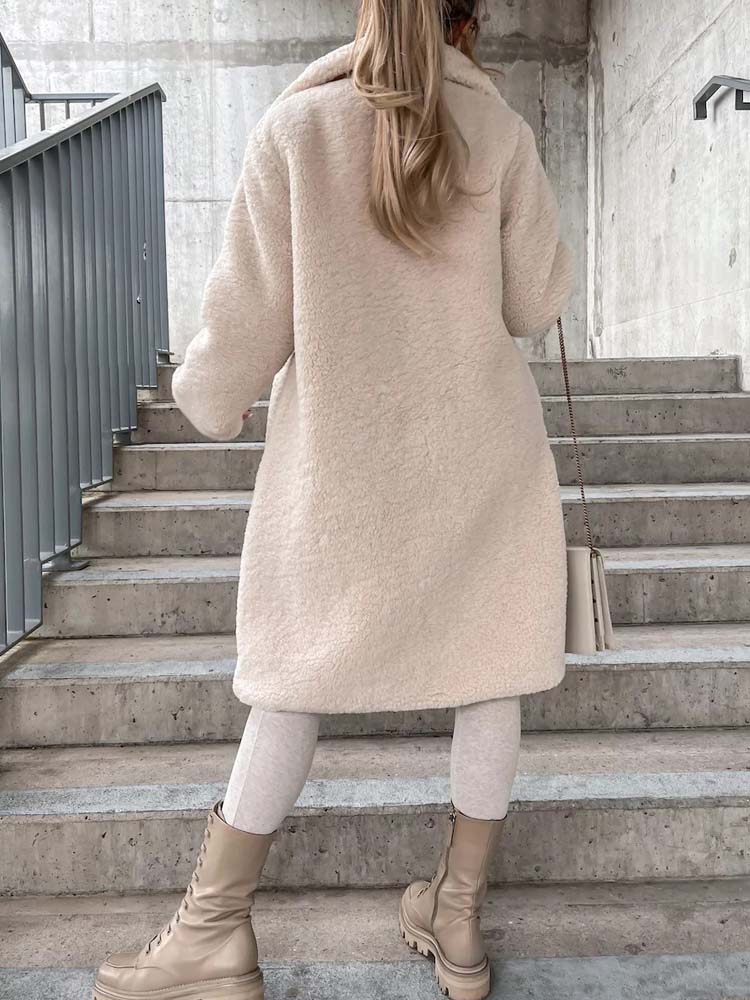 Beige teddy jas gedragen door vrouw die trap beklimt buiten | Boutique Moda